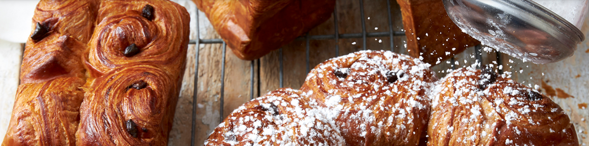 crown brioche and pain au chocolat recipe prepared and being finished with powdered sugar for Delifrance